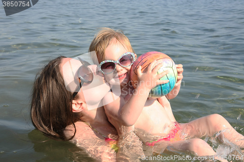 Image of Mother and daughter playing in the sea