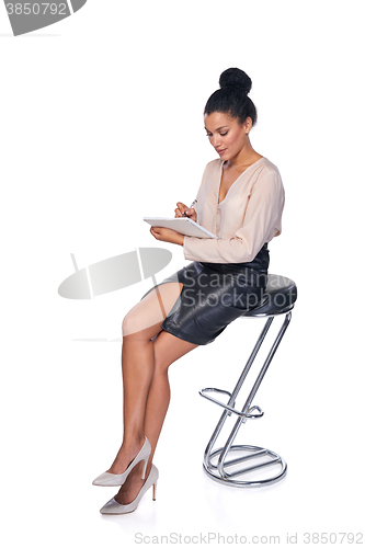 Image of Business woman sitting on the chair and making notes