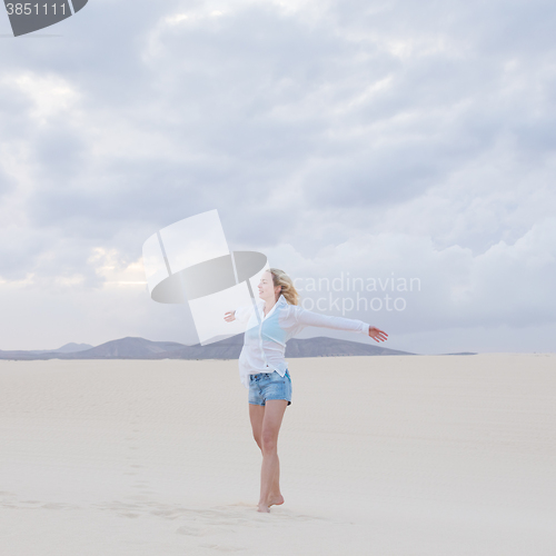 Image of Carefree woman enjoying freedom on beach.