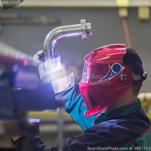 Image of Industrial worker welding in metal factory.