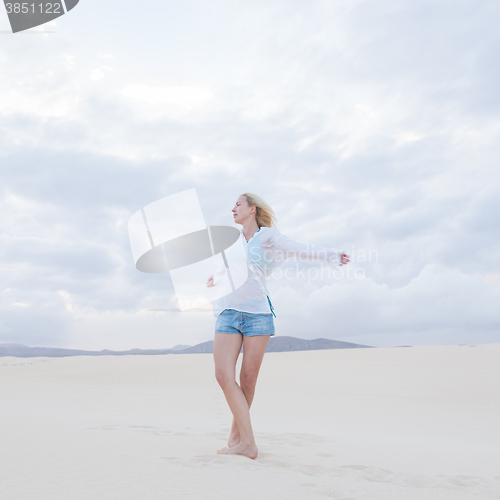 Image of Carefree woman enjoying freedom on beach.