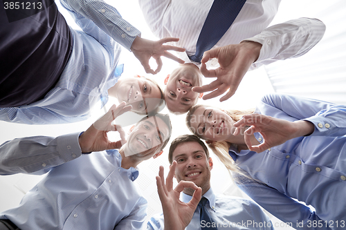 Image of smiling group of businesspeople standing in circle