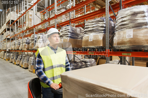 Image of man on forklift loading cargo at warehouse