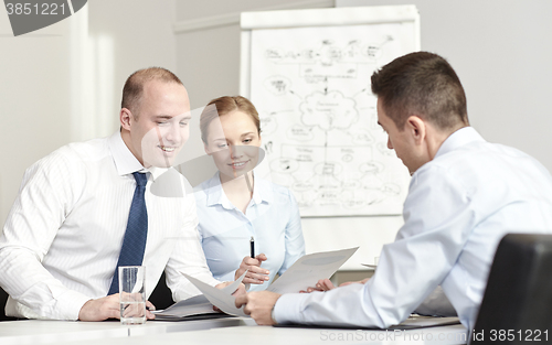 Image of business people with papers meeting in office