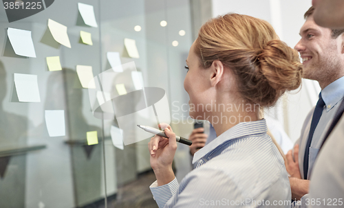 Image of smiling business people with marker and stickers