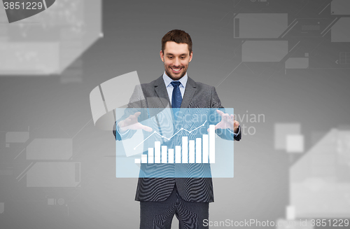 Image of businessman working with virtual chart projection