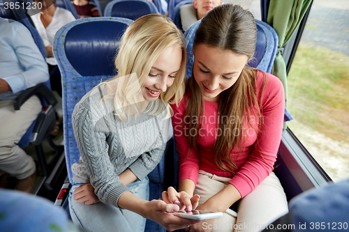 Image of happy young women in travel bus with smartphone