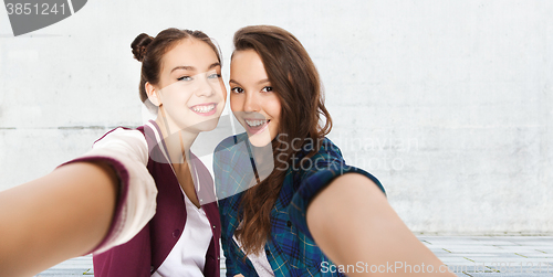 Image of happy smiling pretty teenage girls taking selfie