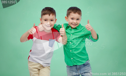 Image of happy boys showing thumbs up over school board