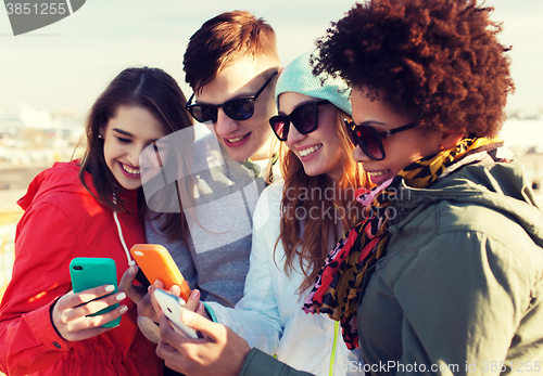 Image of smiling friends with smartphones
