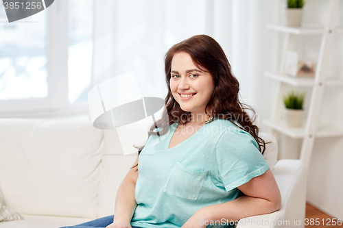 Image of happy young plus size woman at home