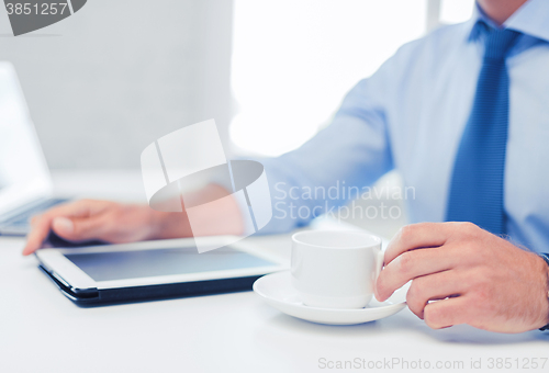 Image of businessman with tablet pc and coffee in office