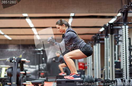 Image of woman doing squats on platform in gym