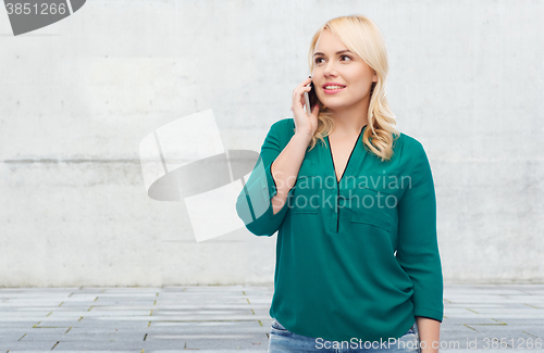 Image of happy young woman calling on smartphone