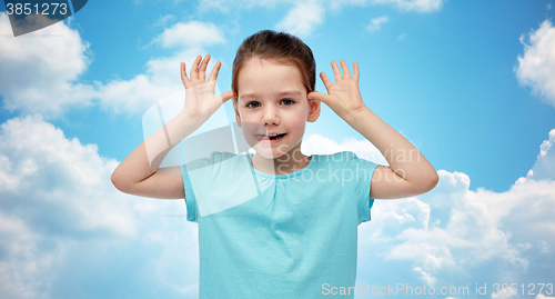 Image of happy little girl having fun and making ears