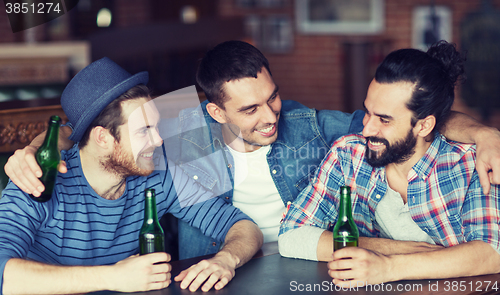 Image of happy male friends drinking beer at bar or pub