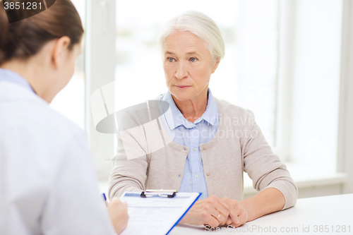 Image of doctor with clipboard and senior woman at hospital