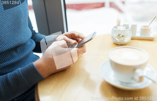 Image of close up of man with smartphones at cafe