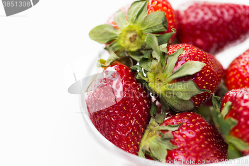 Image of close up of ripe red strawberries over white