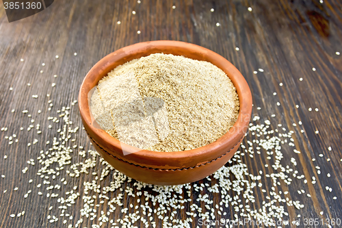 Image of Flour sesame in clay bowl on board