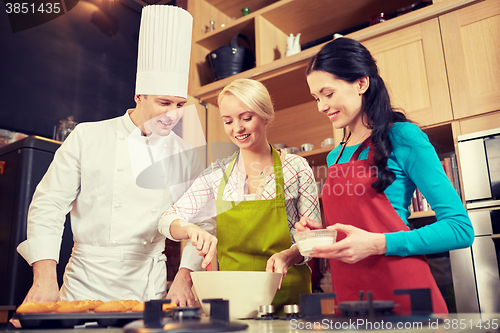 Image of happy women and chef cook baking in kitchen