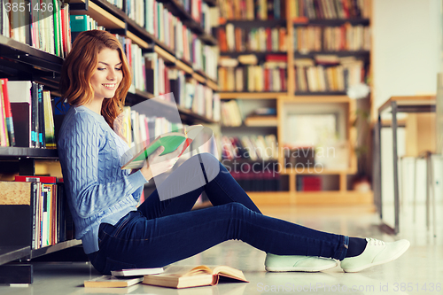 Image of happy student girl reading book in library