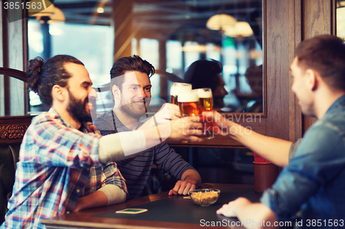 Image of happy male friends drinking beer at bar or pub