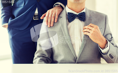 Image of close up of male gay couple with wedding rings on