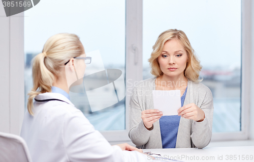 Image of doctor giving prescription to woman at hospital