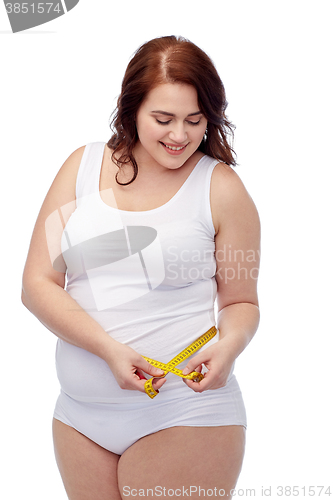 Image of happy young plus size woman with measuring tape