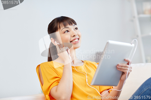 Image of happy asian woman with tablet pc and earphones