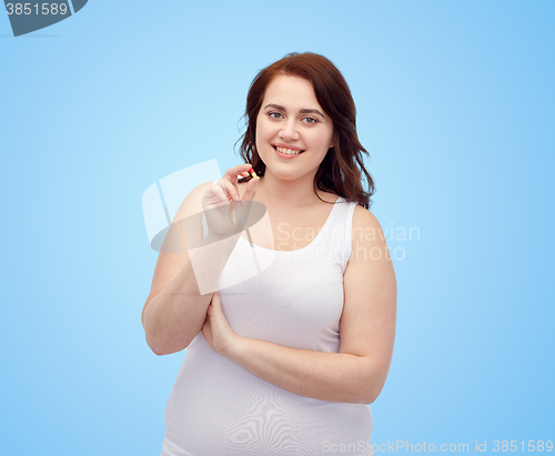 Image of happy plus size woman in underwear with pill