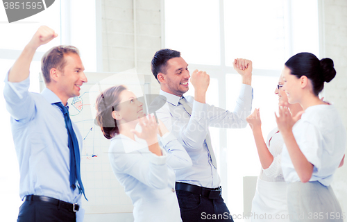 Image of business team celebrating victory in office