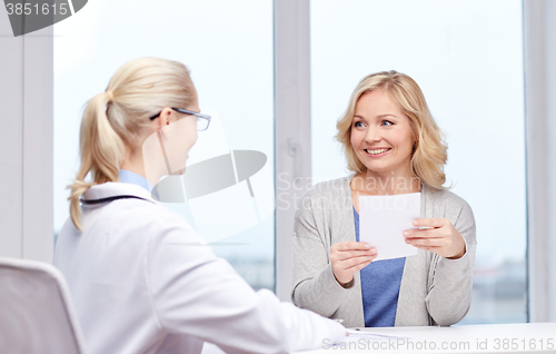 Image of doctor giving prescription to woman at hospital