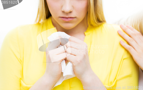 Image of close up of crying teenage girl and friend hand