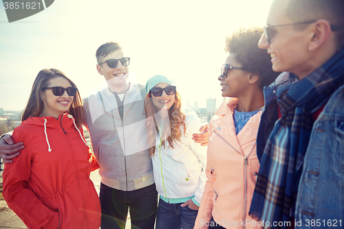 Image of happy teenage friends in shades talking on street