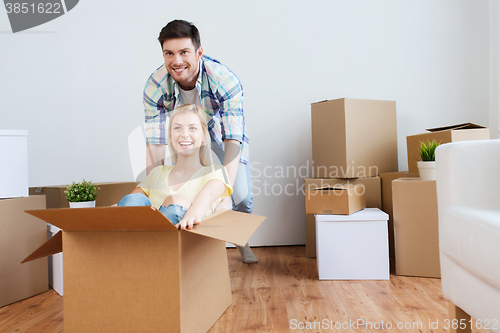 Image of happy couple having fun with boxes at new home