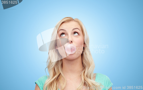 Image of happy young woman or teenage girl chewing gum