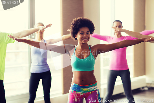 Image of group of smiling people dancing in gym or studio