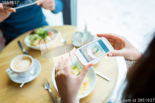Image of close up of couple picturing food by smartphone