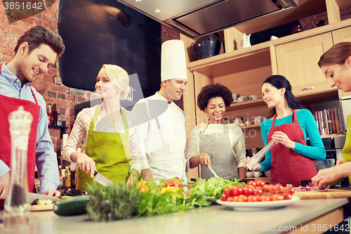 Image of happy friends and chef cook cooking in kitchen