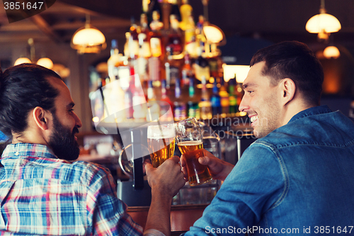 Image of happy male friends drinking beer at bar or pub