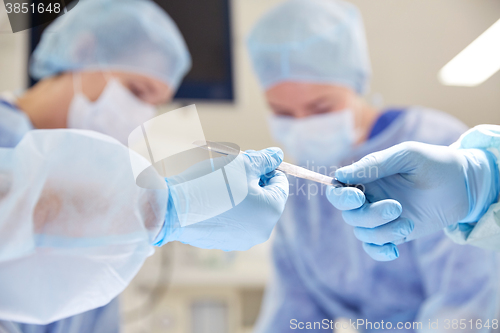 Image of close up of hands with scalpel at operation