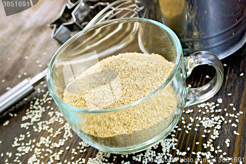 Image of Flour sesame in cup with sieve on board