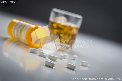 Image of Prescription Drugs Spilled From Fallen Bottle Near Glass of Alco