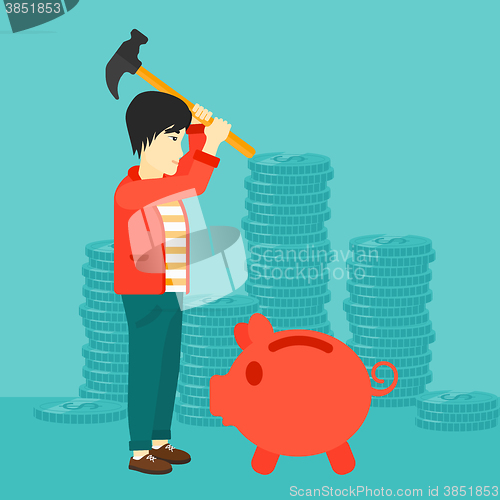 Image of Man breaking piggy bank.