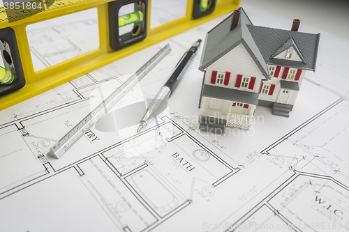 Image of Model Home, Level, Pencil and Ruler Resting on House Plans