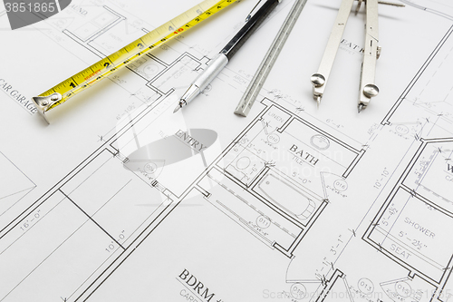 Image of Measuring Tape, Pencil, Ruler and Compass Resting on House Plans