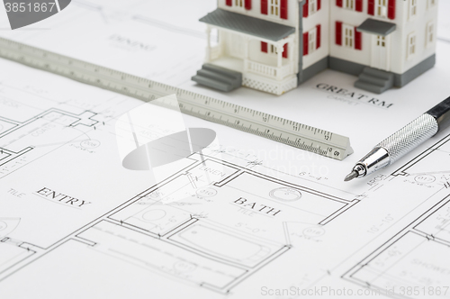 Image of Model Home, Engineer Pencil and Ruler Resting On House Plans