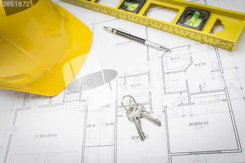 Image of Hard Hat, Pencil, Level and Keys Resting on House Plans